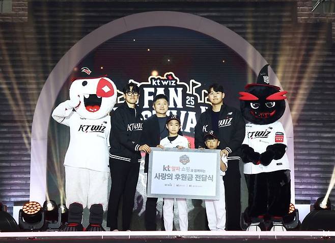 지난달 29일 수원컨벤션센터에서 개최된 ‘2025 kt wiz 팬 페스티벌’에서 후원 유소년야구단을 위한 사랑의 후원금 전달식에서 (왼쪽부터) kt wiz 고영표 선수, KT알파 쇼핑 이정호 부문장, 베스트원야구단 대표 학생들, kt wiz 소형준 선수가 기념촬영을 하고 있다.ⓒKT알파 쇼핑