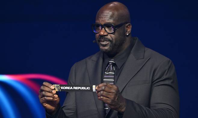 미국 프로농구(NBA) 슈퍼스타 출신 샤킬 오닐이 지난 6일 미국 워싱턴의 케네디센터에서 열린 2026 국제축구연맹(FIFA) 북중미월드컵 조 추첨식에서 한국이 적힌 종이를 펴보이고 있다. 워싱턴=AP연합뉴스