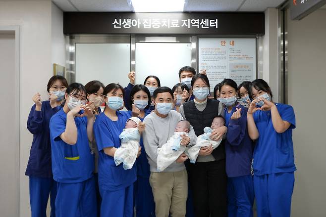 해운대백병원 신생아집중치료지역센터 의료진이 183일간의 치료 끝에 건강하게 퇴원한 세쌍둥이와 부모와 함께 기념 촬영하고 있다. (앞줄 왼쪽 두 번째, 정미림 센터장)