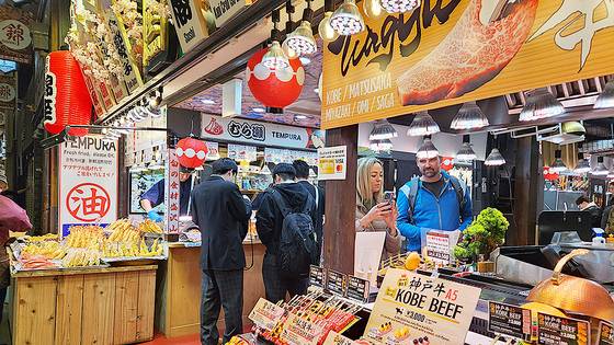 지난 3일 일본 교토 니시키 시장에서 소고기 꼬치구이를 구경하는 외국인 관광객. 오누키 도모코 특파원