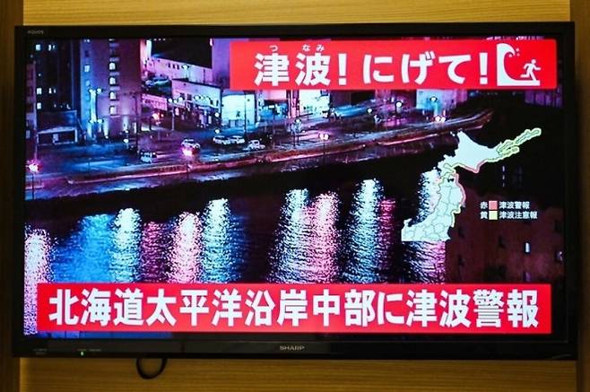 일본 아오모리현 앞바다에서 규모 7.5 지진이 발생한 가운데 홋카이도 삿포로 한 텔레비전 화면에 쓰나미 경고 안내를 하고 있다. AFP 연합뉴스