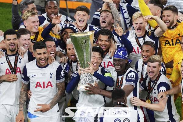 토트넘 홋스퍼의 손흥민이 2024~25시즌 유럽축구연맹(UEFA) 유로파리그(UEL) 결승전에서 우승한 뒤 동료들과 함께 트로피를 들어 올리고 있다. 토트넘은 맨체스터 유나이티드를 1-0으로 꺾고 우승을 차지했으며, 손흥민은 생애 첫 우승컵을 들어 올렸다. /사진=뉴시스(AP)