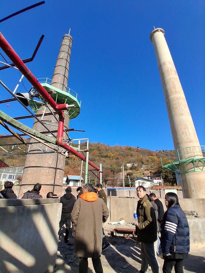 지난 5일 목포 온금동 옛 조선내화 공장터에서 진행된 답사 모습. 한중일 건축사 연구자들이 아래가 불룩한 1930년대 벽돌 굴뚝과 1950년대 콘크리트 굴뚝이 나란히 서있는 북편 영역을 살펴보고 있다. 노형석 기자