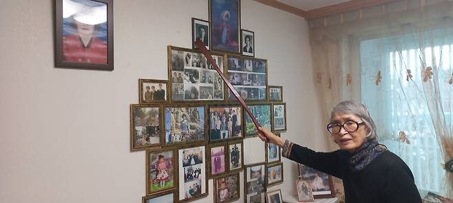 가족사진 설명하는 성경자 할머니 (안산=연합뉴스) 박현수 기자 = 성경자 할머니가 거실 벽면에 걸어 놓은 가족사진을 나무 막대로 가리키며 설명하고 있다. 2025. 12. 12. phyeonsoo@yna.co.kr