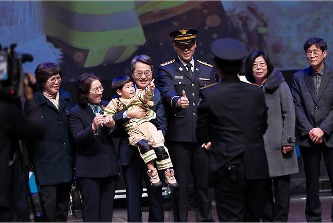 ▲ 19일 오전 경기아트센터에서 열린 2025년 신임 소방공무원 임용식에서 김동연 경기지사가 강동원 소방사 시보에게 임명장을 수여한 뒤 강 시보 아들을 안고 기념촬영을 하고 있다./사진제공=경기도