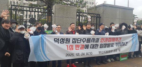 지난 24일 오후 오후 부산법원종합청사 앞에서 덕성원 사건 피해자들이 원고 일부 승소 판결을 자축하고 있다. 국제신문DB