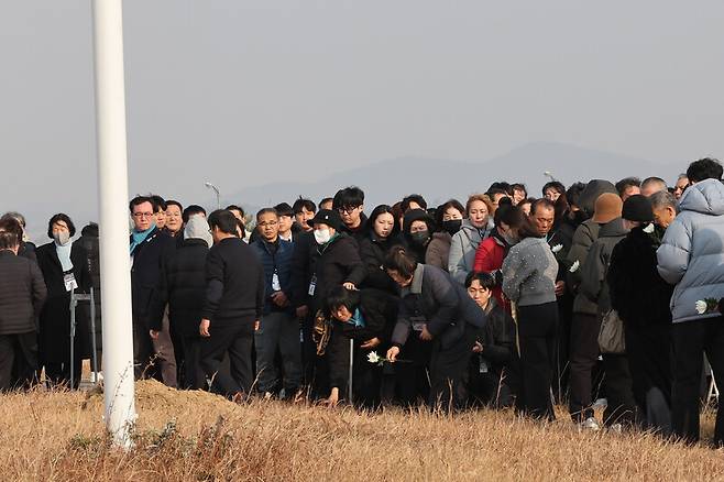 12.29 무안공항 제주항공 여객기참사 유가족들이 29일 오후 전남 무안군 무안국제공항 활주로 안 참사현장인 둔덕을 찾아 헌화하고 있다. 백소아 기자 thanks@hani.co.kr