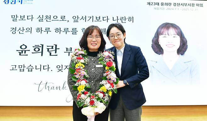 ▲ 조지연 국회의원이 이임하는 윤흐란 경산부시장에게 꽃 목걸이를 걸어준 후 응원의 말을 전하고 있다. 김윤섭기자.