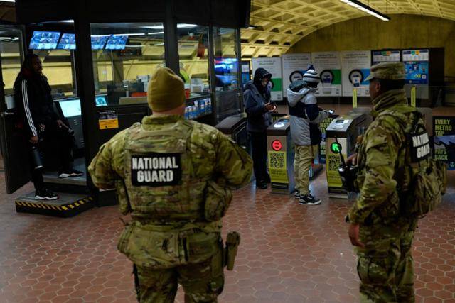 지난달 31일 미국 워싱턴 스미스소니언 지하철역에서 주방위군 대원들이 지하철 이용객들을 지켜보고 있다. 워싱턴=로이터 연합뉴스
