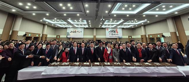 국민의힘 대구시당과 경북도당이 2일 대구 엑스코에서 신년인사회를 열고 ‘2026 새해 복 많이 받으세요’라고 적힌 떡케이크를 자르고 있다.