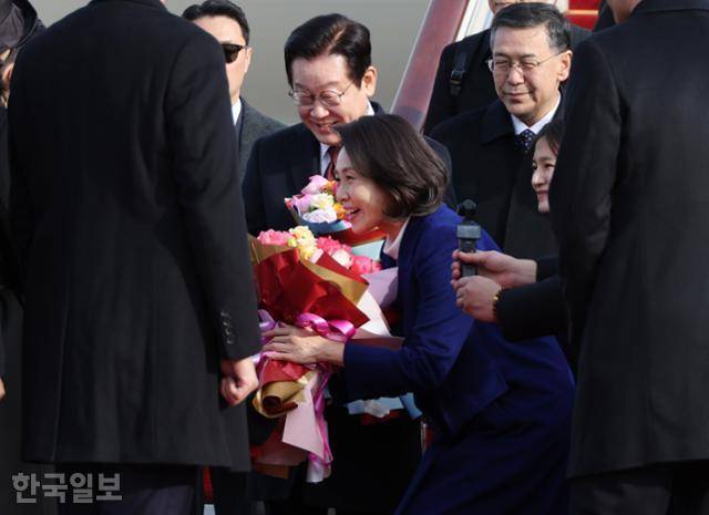 이재명 대통령과 함께 중국을 국빈 방문한 김혜경 여사가 4일 베이징 서우두공항에 도착해 꽃다발을 받고 있다. 베이징=뉴시스