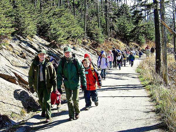 어린이 탐방객들. 레인저 두 명이 어린이들을 인솔하고 있다. 미국 국립공원은 미국의 자연과 역사를 배우는 야외교실이다. 국립공원청은 어린이들을 국립공원의 고객으로 만드는 데 많은 노력을 기울이고 있다. 미래의 국립공원은 그들에게 달려 있기 때문이다.