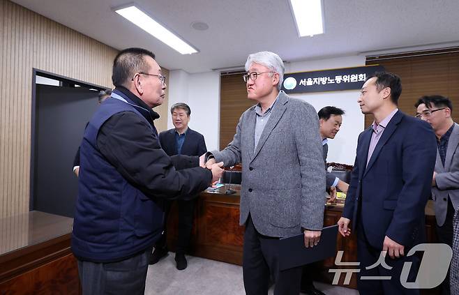 14일 서울 영등포구 서울지방노동위원회에서 열린 특별조정위원회 2차 사후 조정회의에서 서울 시내버스 노사가 임금협상에 극적으로 합의한 뒤 박점곤 서울시버스노동조합 위원장과 김정환 서울시버스사업조합 이사장이 악수를 하고 있다. 2026.1.15/뉴스1 ⓒ News1 박지혜 기자