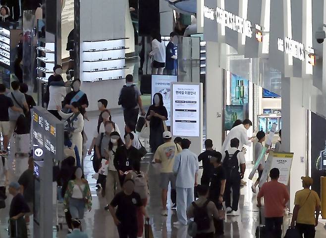 지난 19일 인천국제공항 제1여객터미널 면세구역 내 신라면세점 매장 앞으로 여행객들이 오가고 있다. 뉴스1