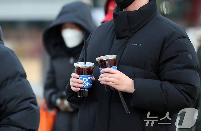 서울 종로구 광화문네거리에서 두터운 옷차림을 한 시민이 차가운 음료를 들고 발걸음을 옮기고 있다. 2025.12.3/뉴스1 ⓒ News1 이호윤 기자
