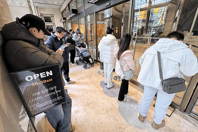 명품 매장 영업 시간 전 줄 선 고객들 - 프랑스 명품 브랜드 샤넬은 지난 13일 '클래식 맥시 핸드백' 등 국내에서 판매하는 주요 제품 가격을 7% 안팎 인상했다. 롤렉스·반클리프 아펠·에르메스·디올 등도 가격을 올렸다. 20일 서울의 한 백화점 샤넬 매장 앞에서 고객들이 영업 시간 전에 줄을 서 있다. /장경식 기자