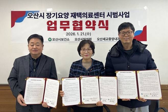 오산시의 '장기요양 재택의료센터 시범사업 업무협약식'에서 참석자들이 협약서를 들어 보이고 있다. 오산시 제공