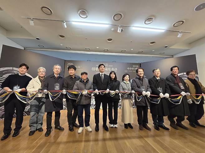 테이프 커팅하는 데브시스터즈와 전통예술 장인들 (서울=연합뉴스) 김주환 기자 = 국내 게임사 데브시스터즈 관계자들과 전통 공예 장인들이 22일 서울 인사동 아라아트센터에서 열린 '쿠키런: 킹덤' 아트 컬래버 특별전 '위대한 왕국의 유산' 기자 간담회 자리에서 한지로 된 기념 테이프를 자르고 있다. 2026.1.22 jujuk@yna.co.kr
