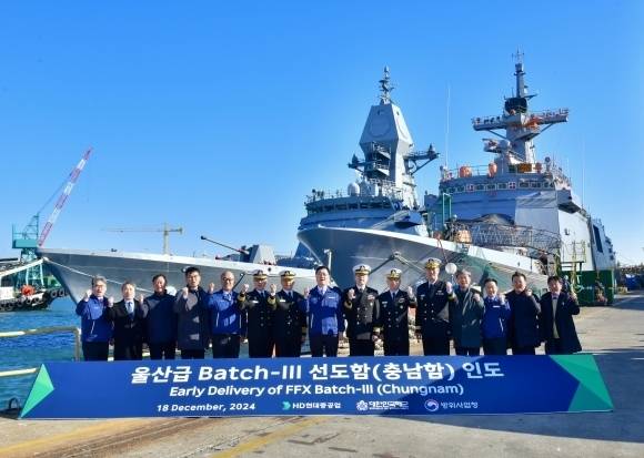 2024년 12월 18일 울산에서 해군에 인계된 충남함 앞에서 방위사업청, 해군, HD현대중공업 관계자들이 기념 촬영을 하고 있다. 방위사업청 제공