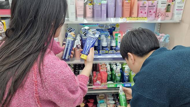 /다이소 제공다이소 매장에서 20~30대 젊은 고객들이 초저가 탈모 케어 제품을 둘러보고 있다.