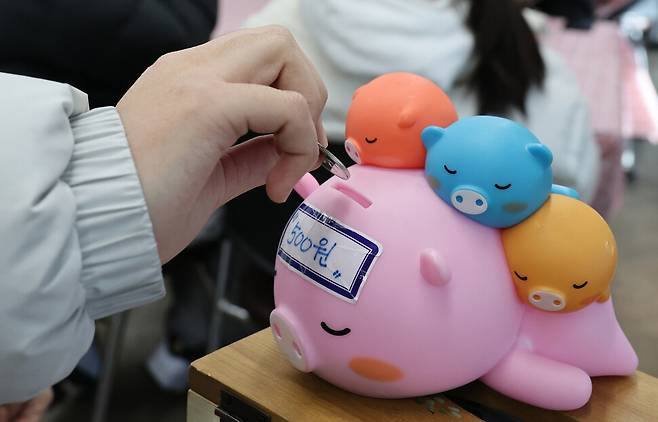 한 학생이 지난 13일 낮 경남 창원시 진해구 500원 식당 들머리에 놓여있는 동전통에 500원을 넣고 있다. 김혜윤 기자 unique@hani.co.kr