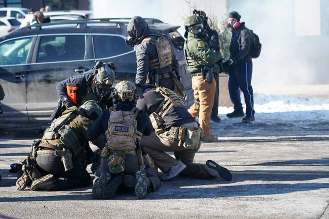 현지시간 24일 미국 미네소타주 미니애폴리스에서 이민세관집행국(ICE) 요원들이 한 남성을 체포하려다 여러 차례 총격을 가한 후, 연방 요원들이 경찰과 대치하며 한 시위자를 억류하고 있다. EPA=연합뉴스
