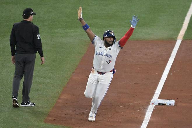 블라디미르 게레로 주니어가 지난해 11월 2일(한국시각) 로저스센터에서 열린 LA 다저스와의 월드시리즈 7차전에서 3회 보 비��의 스리런홈런 때 양팔을 들고 홈으로 쇄도하고 있다. EPA연합뉴스