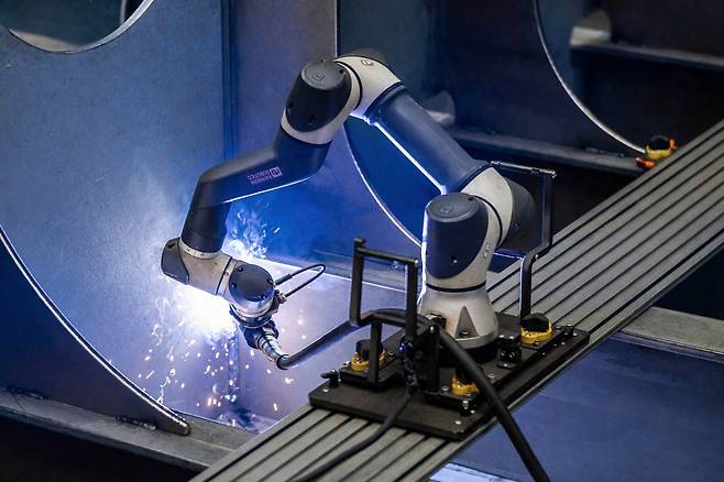 지난 7일 울산 남구 HD현대중공업 용연공장에서 사람 팔 모양의 로봇이 선박 블록 접합부를 용접하고 있는 모습./HD현대중공업