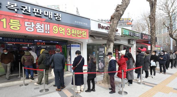 서울의 한 복권판매점 앞에 복권을 사기 위한 시민들이 길게 줄을 서 있다. 뉴스1