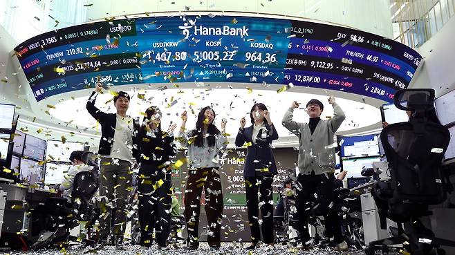 22일 오전 서울 중구 하나은행 본점 딜링룸 현황판에 코스피 지수가 장중 5000을 넘으며 개장하자 직원들이 환호하고 있다. 뉴스1