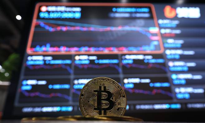 6일 서울 강남구 빗썸 라운지에 설치된 암호화폐 시세 현황판 앞에 비트코인을 형상화한 조형물이 놓여 있다. 뉴스1