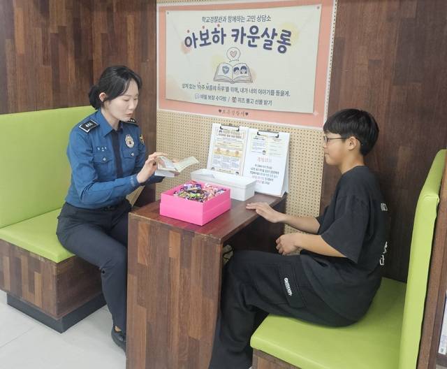 ▲ 보은경찰서 직원이 `아보하 카운살롱'을 찾은 한 학생과 대화하고 있다.