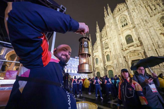 2월 5일 저녁 이탈리아 밀라노 두오모 대성당 앞 광장에서 2026 밀라노 코르티나 동계 올림픽 성화가 니콜레타 마니 이탈리아 발레 무용수를 끝으로 봉송이 끝난 가운데 관계자가 성화를 안전 렌턴에 보관하고 있다. 밀라노=장련성 기자