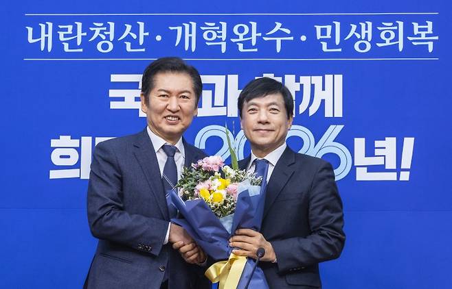 정청래 더불어민주당 대표(왼쪽)가 지난달 12일 국회에서 열린 최고위원회의에서 이성윤 최고위원에게 꽃다발을 전달하고 있다. 연합뉴스