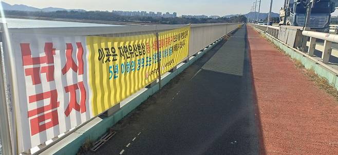 9일 오후 부산 사하구 낙동강하구둑 교량의 인도 구간 안전 난간에 '낚시 금지' 현수막이 붙여져 있다. 백창훈 기자