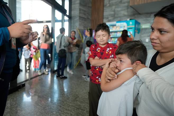 6일(한국시간) 멕시코 과달라하라의 한 보건센터에서 홍역 백신 접종을 기다리던 어린이들이 잔뜩 긴장한 표정으로 보건 요원의 설명을 듣고 있다. 과달라하라|AP뉴시스