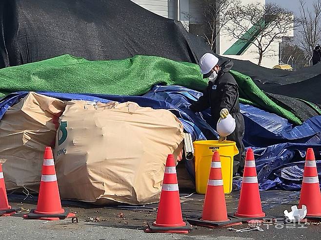 12일 12·29 무안공항 제주항공 여객기 참사 사고기 잔해에 대한 재조사 시작된 가운데 관계자가 파면들 속에 고여 있던 빗물을 퍼내고 있다.
