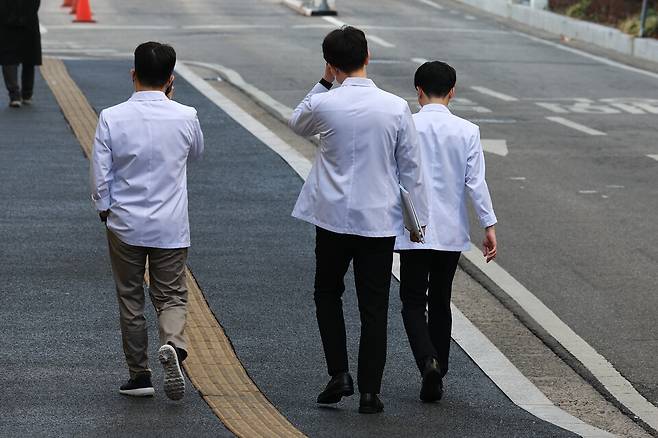 전국 40개 의과대학 총장들이 긴급회의를 열고 의대생들의 집단 휴학계 반려 등 지침을 논의할 것으로 알려진 지난해 3월19일 서울 시내 한 의과대학에서 의료진이 이동하고 있다. ⓒ연합뉴스