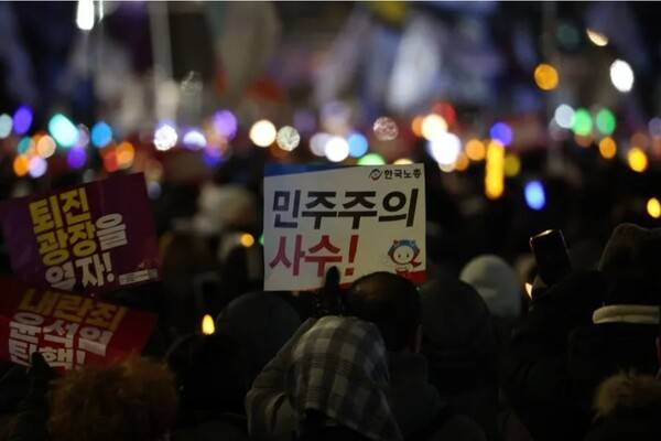 2024년 12월7일 오후 서울 여의도 국회 앞에서 열린 '내란죄 윤석열 퇴진! 국민주권 실현! 사회 대개혁! 범국민 촛불대행진'에서 참석자가 "민주주의 사수" 손팻말을 들고 있다. 2024.12.7. 연합뉴스