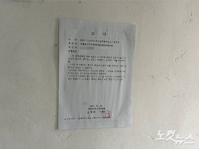 김우권씨 집에 붙은 북부지법 고시. 박인 기자