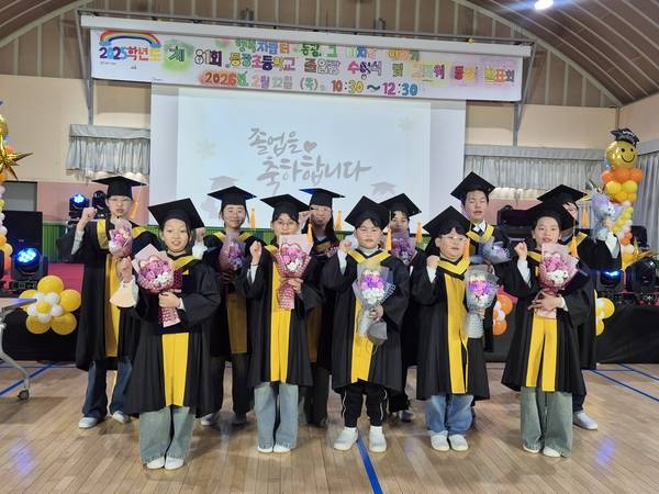지난 12일 열린 고성 동광초등학교 81회 졸업식에서 졸업생 6명을 포함한 전교생 11명이 마지막 기념사진을 찍고 있다./ 문정민 기자