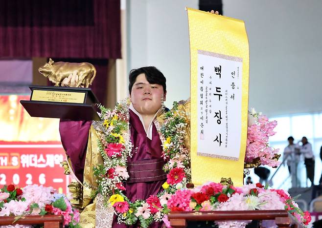 꽃가마에 올라 장사 인증서와 황소 트로피를 들어 보이는 김민재. 사진 대한씨름협회