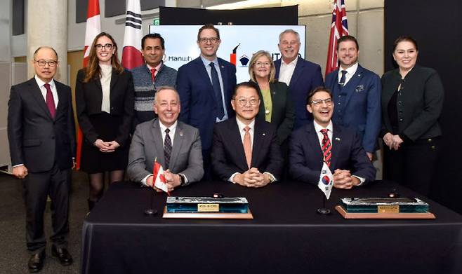 모호크대학 폴 암스트롱 총장(앞줄 왼쪽), 한화오션 김희철 대표(앞줄 가운데), 온타리오조선소 숀 파둘로 대표(앞줄 오른쪽)가 전략적 협력 의향서(LOI)를 체결한 뒤 캐나다 국회의원 등 관계자들과 함께 기념촬영을 하고 있다.(사진=한화오션)