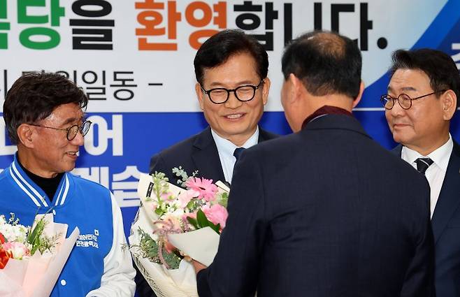 더불어민주당 송영길 전 당 대표가 20일 인천 남동구 인천시당을 찾아 고남석 시당위원장에게 복당 신청서를 제출한 뒤 지지자들로부터 축하 꽃다발을 받고 있다. 연합뉴스