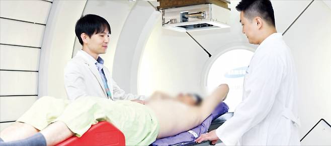 유정일 삼성서울병원 방사선종양학과 교수(왼쪽)가 간암 환자에게 양성자 치료를 시행하고 있다. /삼성서울병원 제공