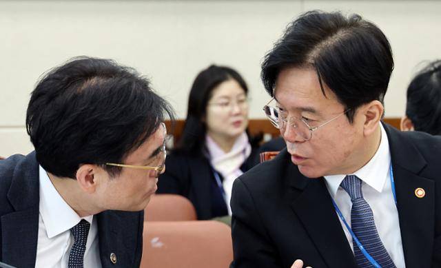 고용노동부 김영훈(오른쪽) 장관과 권창준 차관이 6일 국회에서 열린 기후에너지환경노동위원회 전체회의에서 대화하고 있다. 연합뉴스