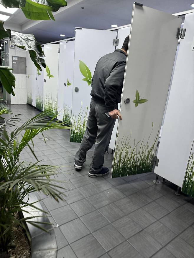 동희오토 사내 하청 관리자가 화장실 문을 수시로 열어보며 노조 홍보 스티커가 붙었는지 확인하고 있다. 이들은 사내 하청 노동자가 대변기를 쓰고 나온 직후 화장실 칸을 열어 내부를 확인했다. 동희오토분회 제공