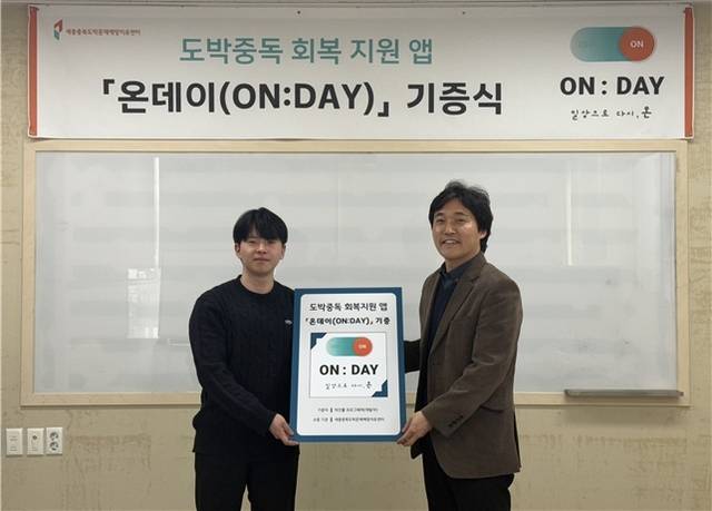 ▲ 지난 20일 김경진 세종충북도박문제예방치유센터장(오른쪽)과 박건률 프로그래머(왼쪽)가 도박중독 회복지원앱 기증서를 들고 기념사진을 찍고 있다./세종충북도박문제예방치유센터 제공