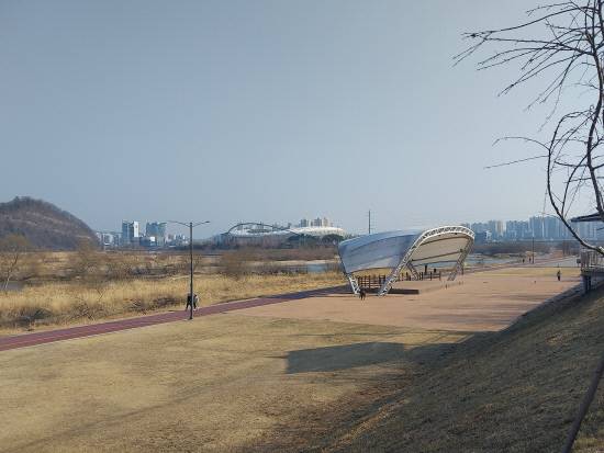 지하대둔치 야외공연장 너머로 진주시종합운동장과 진주 랜드마크 중 하나인 LH본사 타워가 보인다.