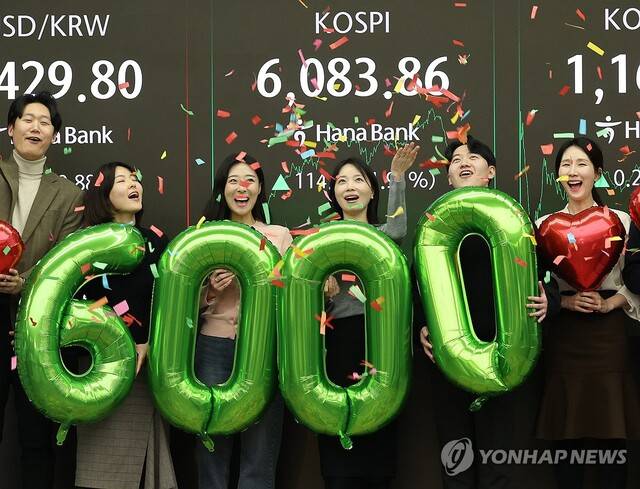 코스피가 사상 처음으로 6,000을 돌파해 거래를 마친 25일 서울 중구 하나은행 딜링룸에서 딜러들이 기념 세리머니를 하고 있다. 연합뉴스 제공